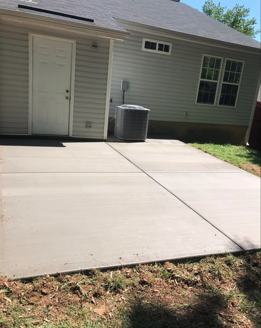 Concrete patio extending along the back of a home