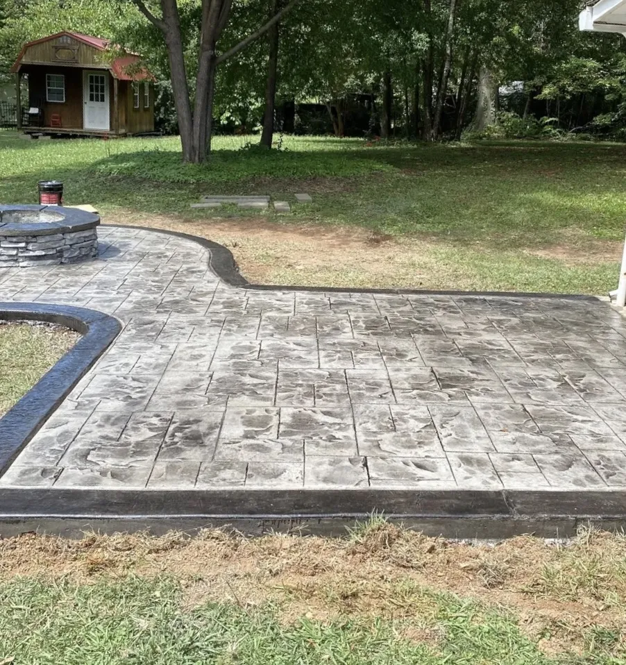 Stamped concrete patio surrounding a stone fire pit